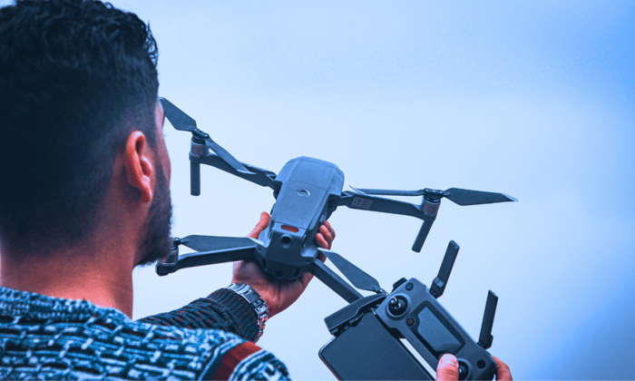 A man holding a drone and controller in his hands