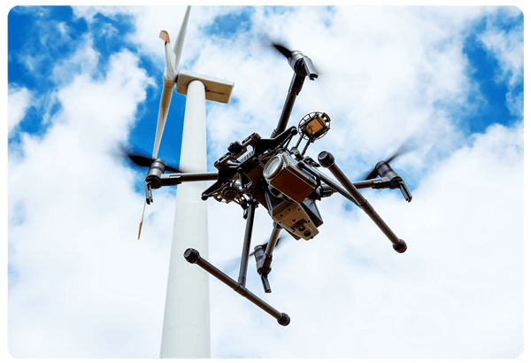 Drone flying next to wind turbine