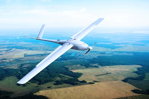 Fixed wing drone flying over countryside
